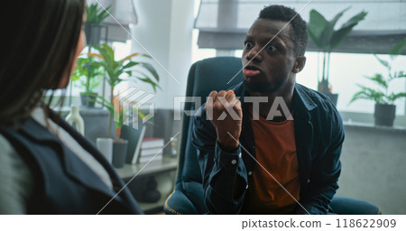 Aggressive man shouts at his girlfriend on counseling session with family psychotherapist 118622909