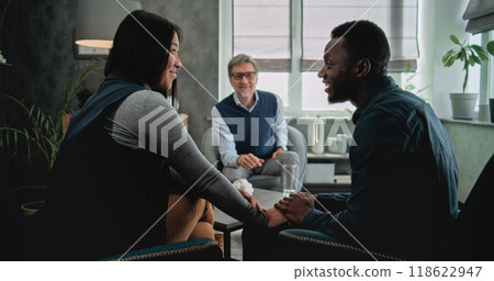 Back view of reunion of tender multiethnic couple holding hands after couples therapy 118622947