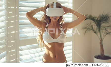 Young woman engages with virtual reality, doing fitness in sunny living room 118623188