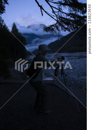 Photographer taking pictures of the landscape at dawn Photographer taking pictures of the landscape at dawn 118623630