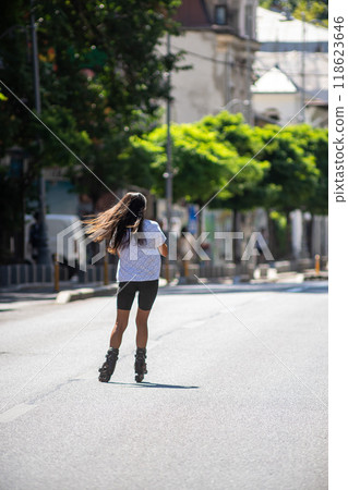 Girl with roller skates riding on the street 118623646