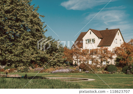 House with nice garden in fall. Flowers in the City Park of Bietigheim-Bissingen, Baden-Wuerttemberg, Germany, Europe. Autumn Park and house, nobody, bush and grenery 118623707