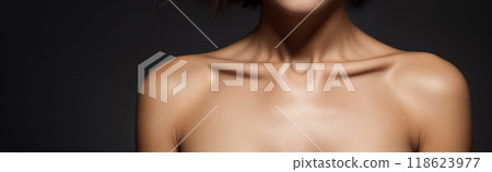 Bare expressive collarbones, shoulders and cleavage of a young woman or girl on a black background 118623977