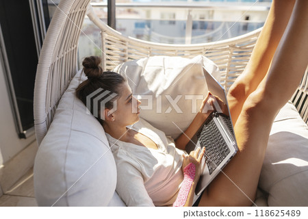 A young woman is working in a cozy and modern indoor space, combining comfort with creativity 118625489