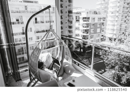 Design a modern balcony oasis with a cozy hammock chair for relaxation and enjoyment Design a modern balcony oasis with a cozy hammock chair for relaxation and enjoyment 118625540