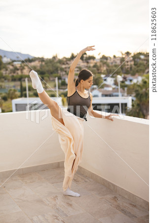 A graceful ballet dance outdoor performance takes place beautifully against the sunset sky A graceful ballet dance outdoor performance takes place beautifully against the sunset sky 118625603