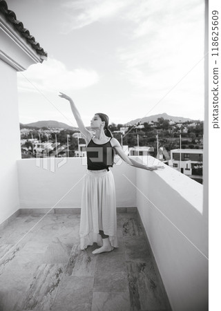 A Graceful Dancer Posing Elegantly on a Beautiful Balcony with Scenic Background 118625609