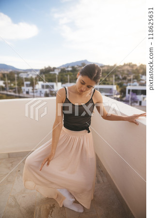 Sophisticated and Elegant Woman Dressed in a Flowing Skirt Standing Gracefully at Sunset 118625631