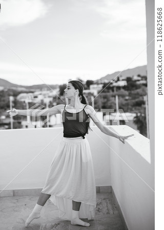 A Graceful Dancer Posing Elegantly on a Scenic Balcony Amidst Beautiful Natural Views 118625668