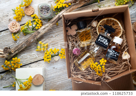 author collection of perfumes around yellow flowers and ingridients served in box .top view. perfumery and life style concept author collection of perfumes around yellow flowers and ingridients served in box .top view. perfumery and life style concept 118625733