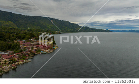 Aerial drone of Tourist spot Tuk Tuk on Lake Toba and the coast of Samosir Island. Sumatra, Indonesia. Tropical landscape. Aerial drone of Tourist spot Tuk Tuk on Lake Toba and the coast of Samosir Island. Sumatra, Indonesia. Tropical landscape. 118626012