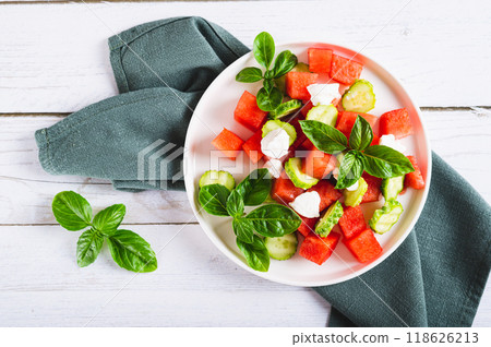Close up of delicious salad of watermelon, cucumber and ricotta on a plate on the table top view 118626213