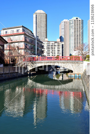 Red Tsukuda Kobashi Bridge and high-rise apartment buildings reflected on the water surface 118628666