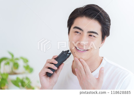 Man shaving his beard with a shaver 118628885