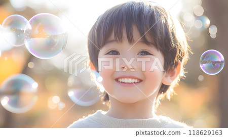 Close-up of a smiling boy's face surrounded by soap bubbles 118629163