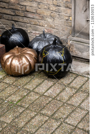 Halloween creative black pumpkins decorated outdoor cafe or restaurant terrace in America or Europe with traditional attributes of Halloween. Frontyard decoration Halloween creative black pumpkins decorated outdoor cafe or restaurant terrace in America or Europe with traditional attributes of Halloween. Frontyard decoration 118630053