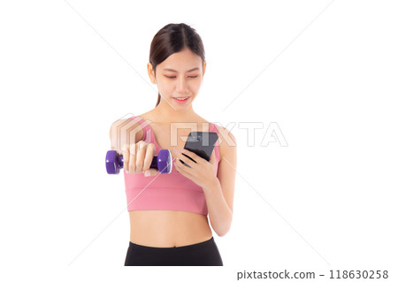 Portrait young asian woman lifting punch dumbbell and watching smartphone isolated. Portrait young asian woman lifting punch dumbbell and watching smartphone isolated. 118630258