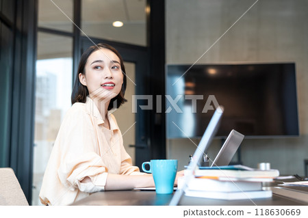 一位女士在電腦上工作時看著窗外的景色 118630669