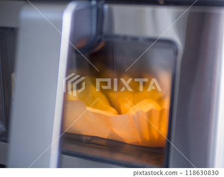 Golden potatoes bake evenly in an air fryer creating crispy edges and tender insides. The air fryer circulates heat, ensuring that every piece of potato is cooked to perfection using the air fryer. 118630830