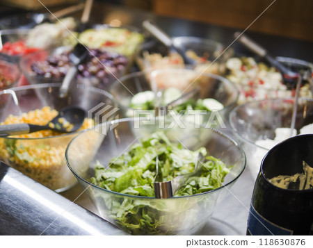 Various fresh vegetables in glass salad bowls with metal spoon creating colorful and healthy display. Fresh vegetables offer vibrant nutrition and taste. Fresh vegetables in bowls ready to serve. Various fresh vegetables in glass salad bowls with metal spoon creating colorful and healthy display. Fresh vegetables offer vibrant nutrition and taste. Fresh vegetables in bowls ready to serve. 118630876