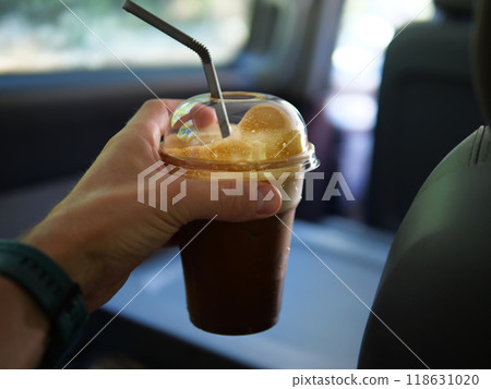 Cold brew coffee in plastic cups in hand, refreshing and invigorating Cold brew coffee, rich and smooth, ready to enjoy. summer with cold brew coffee, perfect for on-the-go refreshment. 118631020