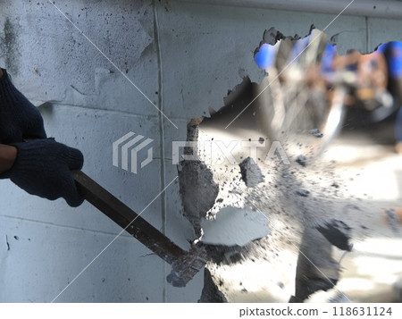 worker hit on old wall by hammer worker hit on old wall by hammer 118631124