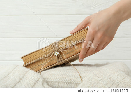 Books with flowers wrapped in burlap thread on a light background. Books with flowers wrapped in burlap thread on a light background. 118631325
