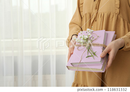Aesthetics of books with flowers on a light background. 118631332