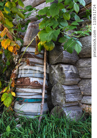 A tall stack of iron buckets stand in the corner of a wooden house 118631714