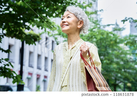 Cute senior woman with shopping bag going out Cute senior woman with shopping bag going out 118631878