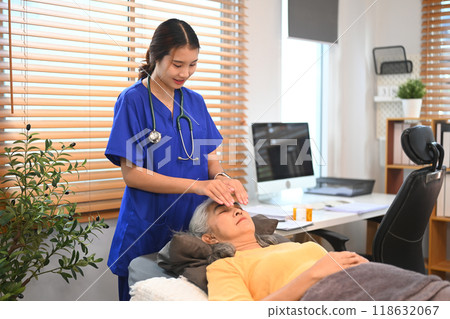 Physiotherapist doing Reiki treatment session to mature woman at clinic. Alternative medicine concept Physiotherapist doing Reiki treatment session to mature woman at clinic. Alternative medicine concept 118632067