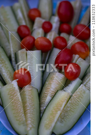 Sliced cucumbers and whole cherry tomatoes in a plate Sliced cucumbers and whole cherry tomatoes in a plate 118632333