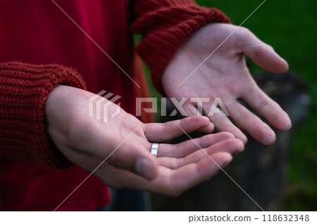 Empty palms of a man up close in a sweater. An engagement ring on her finger Empty palms of a man up close in a sweater. An engagement ring on her finger 118632348
