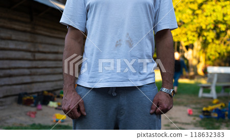 Baby's footprints on the T-shirt. Dirty footprints of a child on a man's T-shirt 118632383