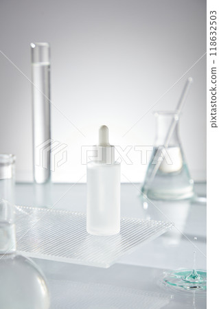 A white background and rugged platform display unlabeled serum bottles, surrounded by glass equipment laboratory with transparent solution placed on clean water surface. A white background and rugged platform display unlabeled serum bottles, surrounded by glass equipment laboratory with transparent solution placed on clean water surface. 118632503