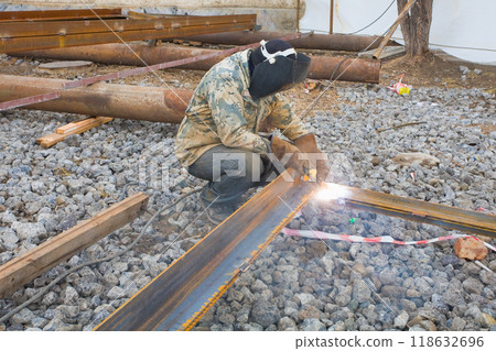 Welder in mask welding metal construction on open air. 118632696