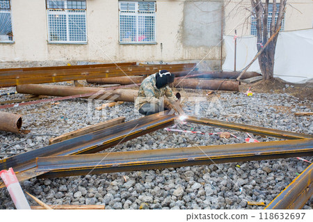 Welder in mask welding metal construction on open air. 118632697