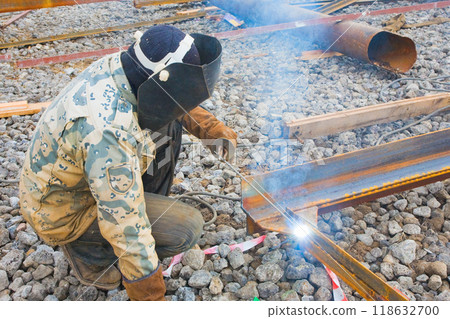 Welder in mask welding metal construction on open air. Welder in mask welding metal construction on open air. 118632700