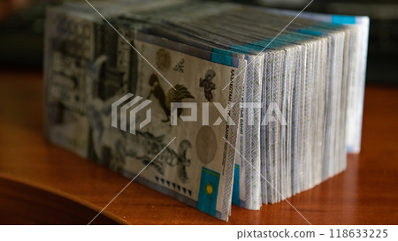 Thick wad of money cash on table 118633225