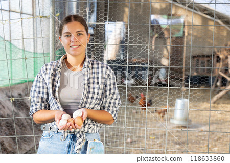 Young woman posing on chicken farm with eggs Young woman posing on chicken farm with eggs 118633860