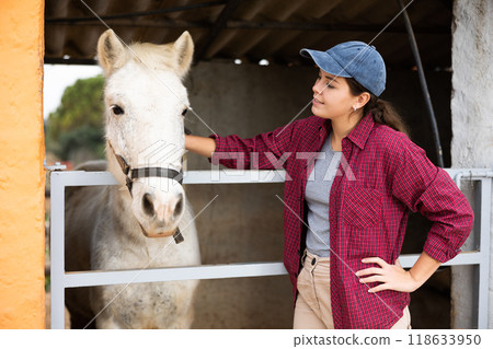 Woman brushing, taking on walk, feeding horses Woman brushing, taking on walk, feeding horses 118633950