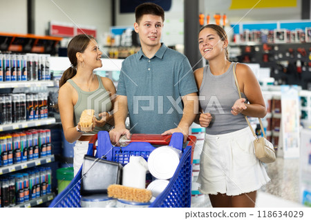 Positive family discussing purchases while standing with cart in hardware store 118634029