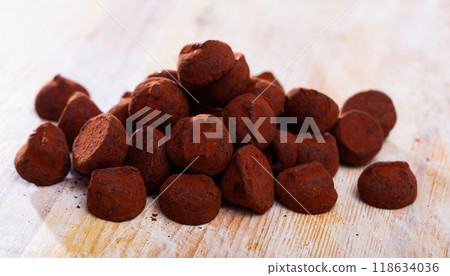 Dessert truffles sprinkled with cocoa on wooden table 118634036
