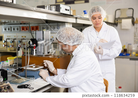 Portrait of male and female scientists in white coats working in biochemical laboratory 118634259