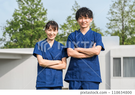 Male and female medical staff (occupational therapists and nurses) wearing scrubs in front of a hospital or facility 118634800
