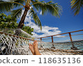Beach travel holiday vacation woman feet selfie lying down relaxing on hammock outside sunbathing. Girl relaxing taking pov photo of her legs sun tanning in tropical summer destination 118635136