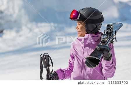 Skiing woman portrait. Skier woman athlete going skiing on slope ski piste wearing helmet and ski goggles in winter nature landscape. Winter sports active lifestyle Skiing woman portrait. Skier woman athlete going skiing on slope ski piste wearing helmet and ski goggles in winter nature landscape. Winter sports active lifestyle 118635700