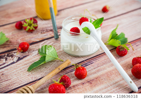 homemade sweet yogurt in a jar with strawberries, on a wooden table homemade sweet yogurt in a jar with strawberries, on a wooden table 118636318