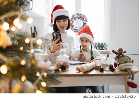 Mother and daughter baking Christmas cookies together at home Mother and daughter baking Christmas cookies together at home 118636420