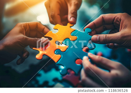 A group of people putting a piece of jigsaw puzzle together 118636526
